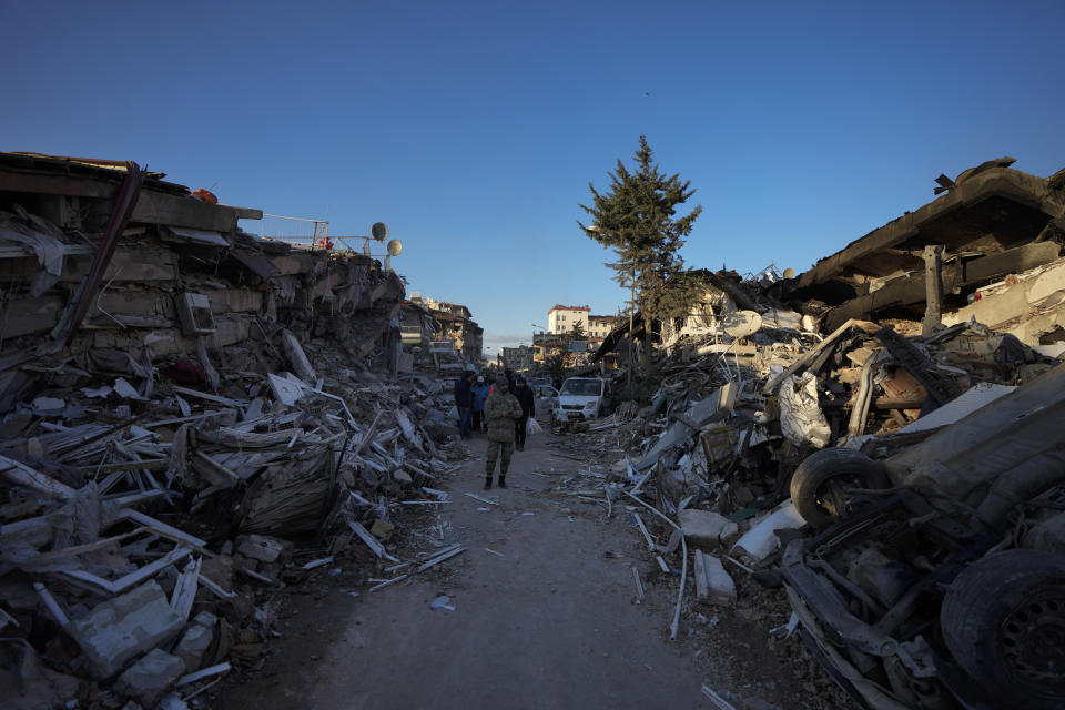 A man walks amid destroyed buildings in Antakya, southern Turkey, Wednesday, Feb. 8, 2023. With the hope of finding survivors fading, stretched rescue teams in Turkey and Syria searched Wednesday for signs of life in the rubble of thousands of buildings toppled by a catastrophic earthquake. (AP Photo/Khalil Hamra)