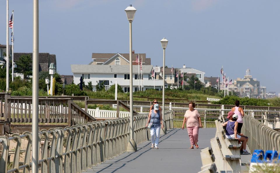 People walk along the boardwalk in Sea Girt Wednesday, August 11, 2021.