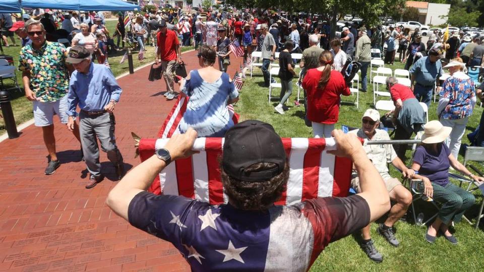 Darrell Dillard, a veteran from Atascadero, rolls up a flag after the ceremony at a Memorial Day ceremony at Faces of Freedom Veterans Memorial in Atascadero in 2021.