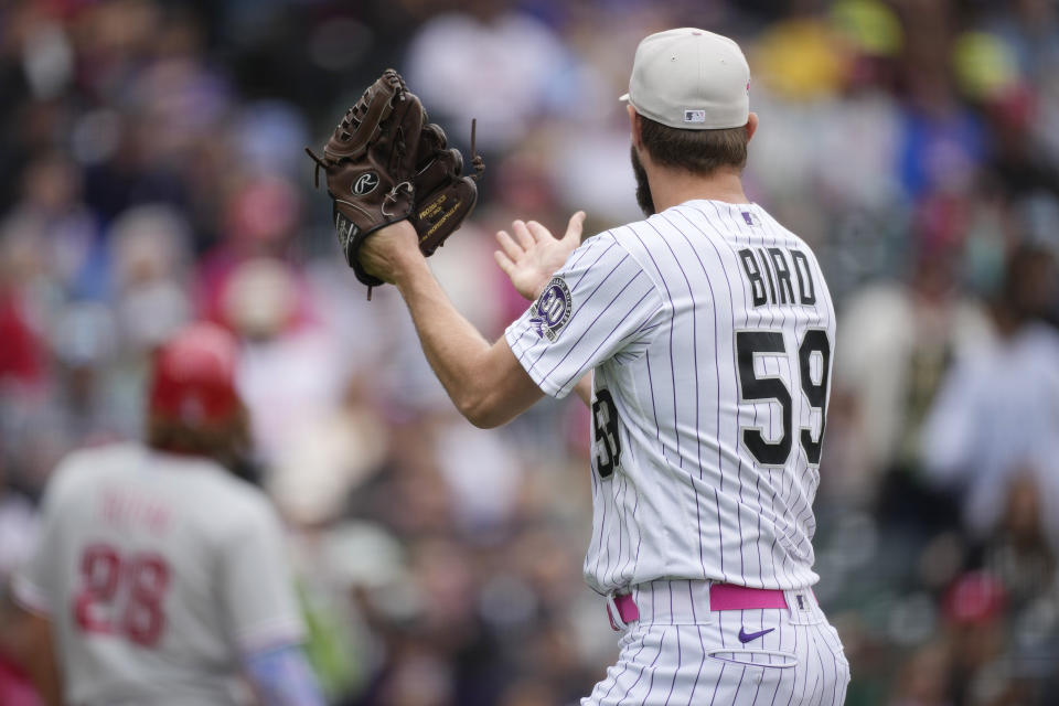 Colorado Rockies relief pitcher Jake Bird claps his glove and looks to the Philadelphia Phillies dugout after retiring the Phillies' Bryson Stott to end the top of the seventh inning of a baseball game Sunday, May 14, 2023, in Denver. Phillies' Bryce Harper pursued Byrd which emptied both dugouts in a mild dustup between the teams. (AP Photo/David Zalubowski)