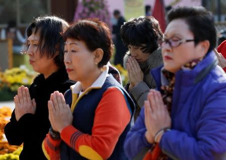 Women pray for their respective family members taking the annual college entrance examinations at a Buddhist temple in Seoul, South Korea, November 17, 2016. REUTERS/Kim Kyung-Hoon