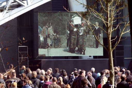 People watch the remembrance service on a large screen in Lommel, Belgium, for the local victims of last week's bus crash in Switzerland, on March 21, 2012. Belgium's king and the Dutch crown prince joined thousands of mourners in a highly emotional homage Wednesday to the victims of last week's fatal school bus crash in a Swiss alpine tunnel