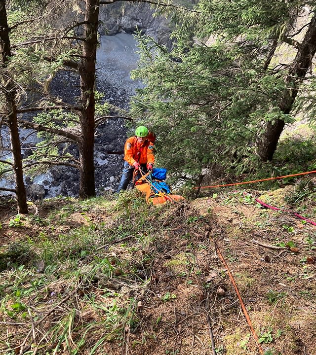 rescuer rappels down slope