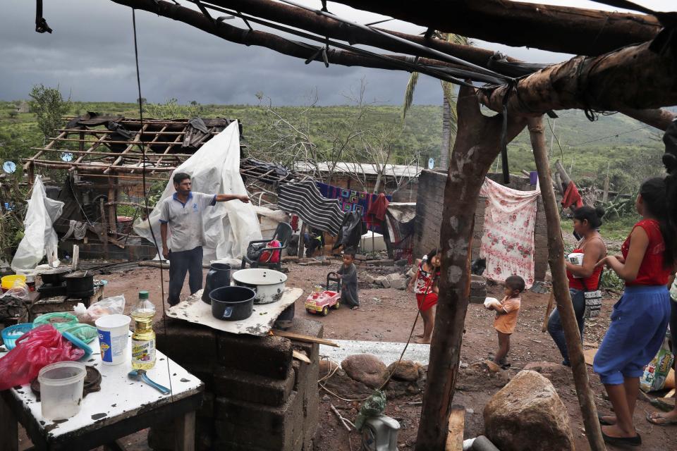 A family works to put their home back in order in the aftermath of Hurricane Willa, in Escuinapa, Mexico, Wednesday, Oct. 24, 2018. Emergency workers on Wednesday were struggling to reach beach towns left incommunicado by a blow from Willa. (AP Photo/Marco Ugarte)