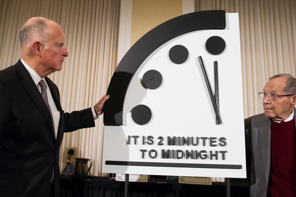 Former California Gov. Jerry Brown, left, and former Secretary of Defense William Perry unveil the Doomsday Clock during the Bulletin of the Atomic Scientists news conference in Washington, Thursday, Jan. 24, 2019.  The Doomsday Clock is set at two minutes to midnight.