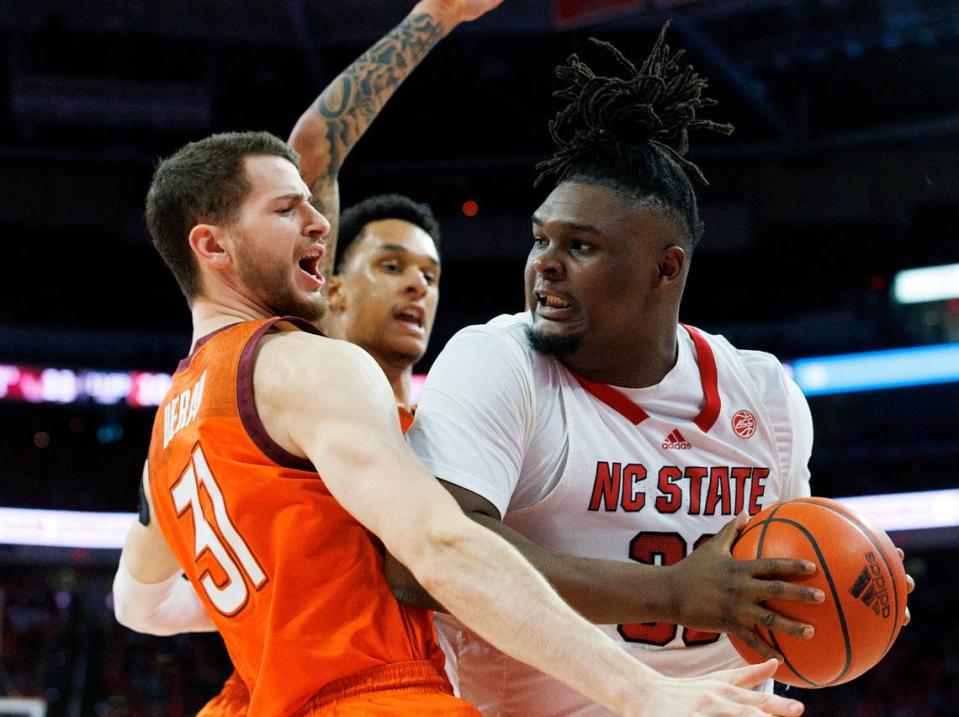 N.C. State’s DJ Burns Jr. looks to pass around Virginia Tech’s Robbie Beran and Lynn Kidd during the first half of the Wolfpack’s game on Saturday, Jan. 20, 2024, at PNC Arena in Raleigh, N.C.