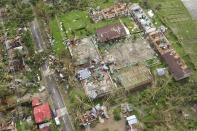 An aerial view shows damaged houses after Typhoon Haiyan hit Iloilo Province, central Philippines November 9, 2013. One of the strongest typhoons ever to make landfall devastated the central Philippines, killing more than 1,000 people in one city alone and 200 in another province, the Red Cross estimated on Saturday, as reports of high casualties began to emerge. REUTERS/Raul Banias (PHILIPPINES - Tags: TPX IMAGES OF THE DAY ENVIRONMENT DISASTER)