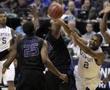 Kentucky's Aaron Harrison (2) loses control of the ball on his way to the basket as Kansas State's D.J. Johnson and Wesley Iwundu (25) defend during the first half of a second-round game in the NCAA college basketball tournament Friday, March 21, 2014, in St. Louis. (AP Photo/Jeff Roberson)