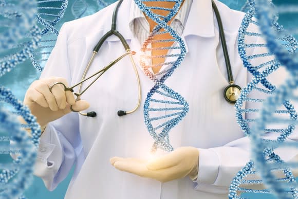 A person in a white lab coat with a stethoscope around their neck uses scissors to snip away at an image of a double helix being held in their hand.