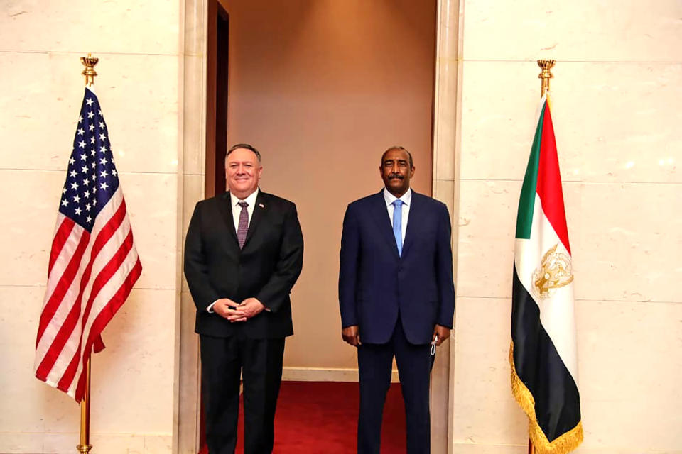 FILE - In this Aug. 25, 2020 file photo, U.S. Secretary of State Mike Pompeo stands with Sudanese Gen. Abdel-Fattah Burhan, the head of the ruling sovereign council, in Khartoum, Sudan. The U.S. Embassy in Khartoum said the administration removed Sudan from the U.S. list of state sponsors of terrorism, a move that could help the African country get international loans to revive its battered economy and end its pariah status. The embassy said in a Facebook post that the removal of Sudan from the list is effective as of Monday, Dec. 14, 2020. Delisting Sudan from the state sponsors blacklist is a key incentive for the Sudanese government to normalize relations with Israel. (Sudanese Cabinet via AP, File)