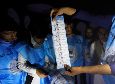 Afghan election commission workers count ballot papers of the presidential election in Jalalabad