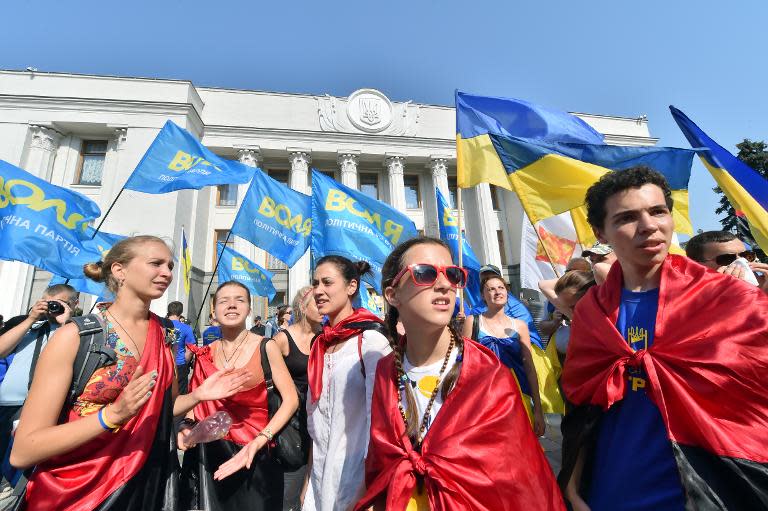 Protesters wave flags and shout slogans as they rally against corruption in front of the Ukrainian parliament in Kiev on August 14, 2014