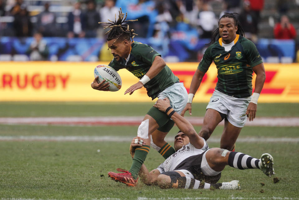 South Africa's Selvyn Davids, left, is tackled by Fiji's Meli Derenalagi, center, during the Los Angeles Sevens rugby tournament final Sunday, March 1, 2020, in Carson, Calif. (AP Photo/Ringo H.W. Chiu)