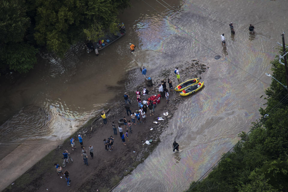 People watch as people are rescued and brought to shore.