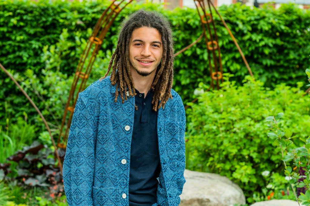 Tayshan Hayden-Smith poses in front of the “Hands Off Mangrove” garden at the Chelsea Flower Show.   (Guy Bell/Shutterstock)