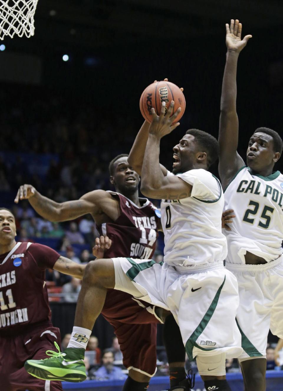 Cal Poly guard Dave Nwaba (0) drives against Texas Southern guard Ray Penn Jr. (14) in the first half of a first-round game of the NCAA college basketball tournament on Wednesday, March 19, 2014, in Dayton, Ohio. Cal Poly forward Joel Awich (25) and Texas Southern guard Lawrence Johnson-Danner (11) watch. (AP Photo/Al Behrman)