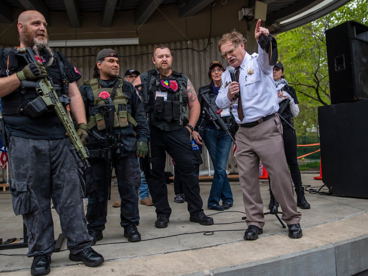 Barry County Sheriff Dar Leaf, front right, speaks next to members of the Michigan Liberty Militia during the “American Patriot Rally-Sheriffs speak out” event at Rosa Parks Circle in downtown Grand Rapids, Michigan, Monday, 18 May, 2020 ((MLive/Grand Rapids Press via the Associated Press))