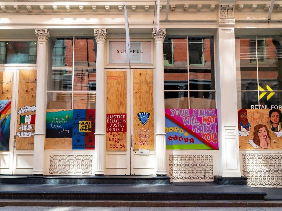 Street art is on display on the boarded-up windows of Sunspel in SoHo on June 20, 2020 in New York City.