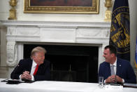 President Donald Trump laughs with Oklahoma Gov. Kevin Stitt during a roundtable with governors on the reopening of America's small businesses, in the State Dining Room of the White House, Thursday, June 18, 2020, in Washington. (AP Photo/Alex Brandon)