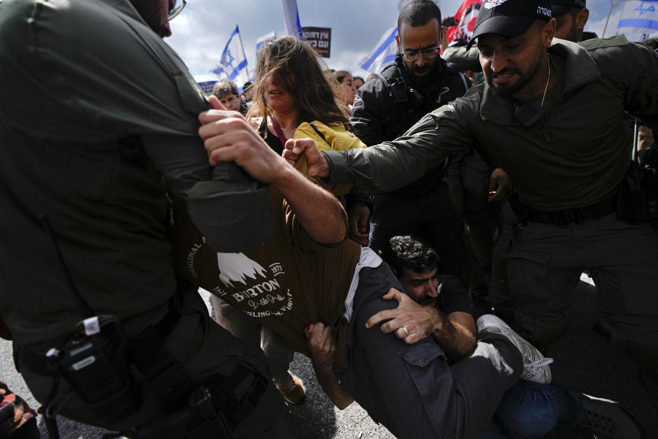 Israelis scuffles with police during a protest against Prime Minister Benjamin Netanyahu's judicial overhaul plan outside the parliament in Jerusalem, Monday, March 27, 2023. (AP Photo/Ariel Schalit)