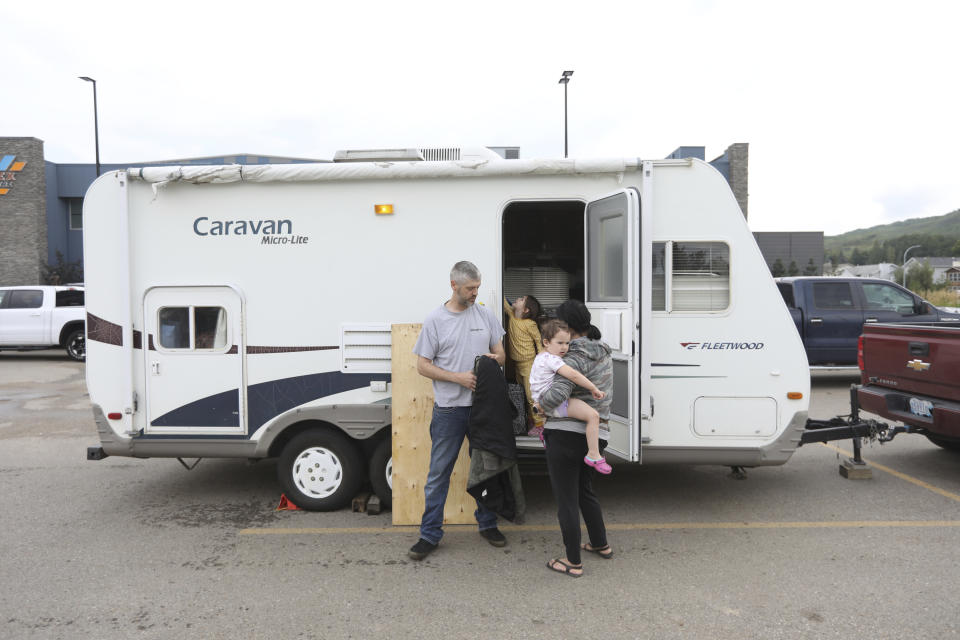 Stuart York and his family are seen outside their travel trailer at the evacuation centre in Peace River, Alta., Friday, Aug. 18, 2023. (Jason Franson /The Canadian Press via AP)