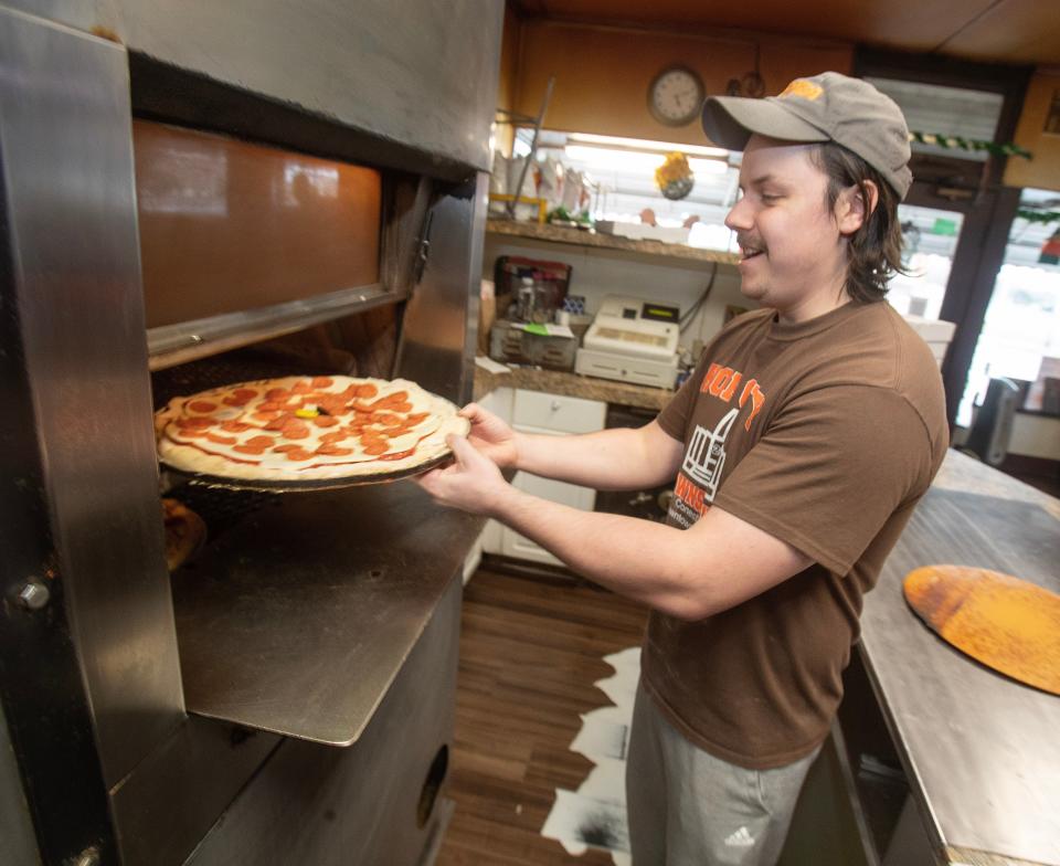 Jarrod Kasunick adds a pie to the oven at Kraus' Pizza northeast side Massillon location.