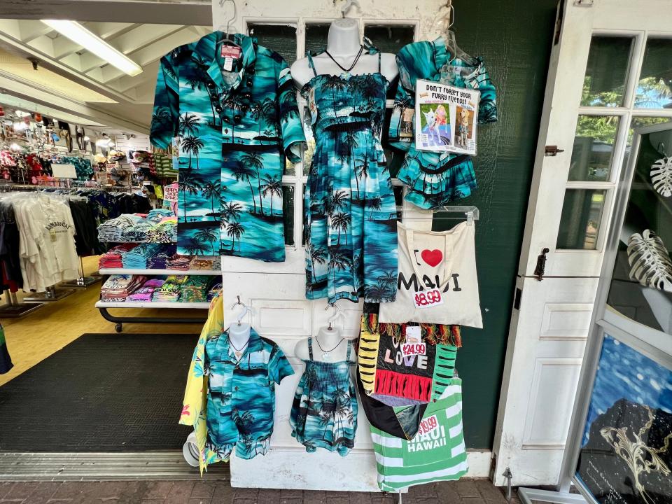 Blue and black Hawaiian shirts and dresses in adult and child sizes in a gift shop display