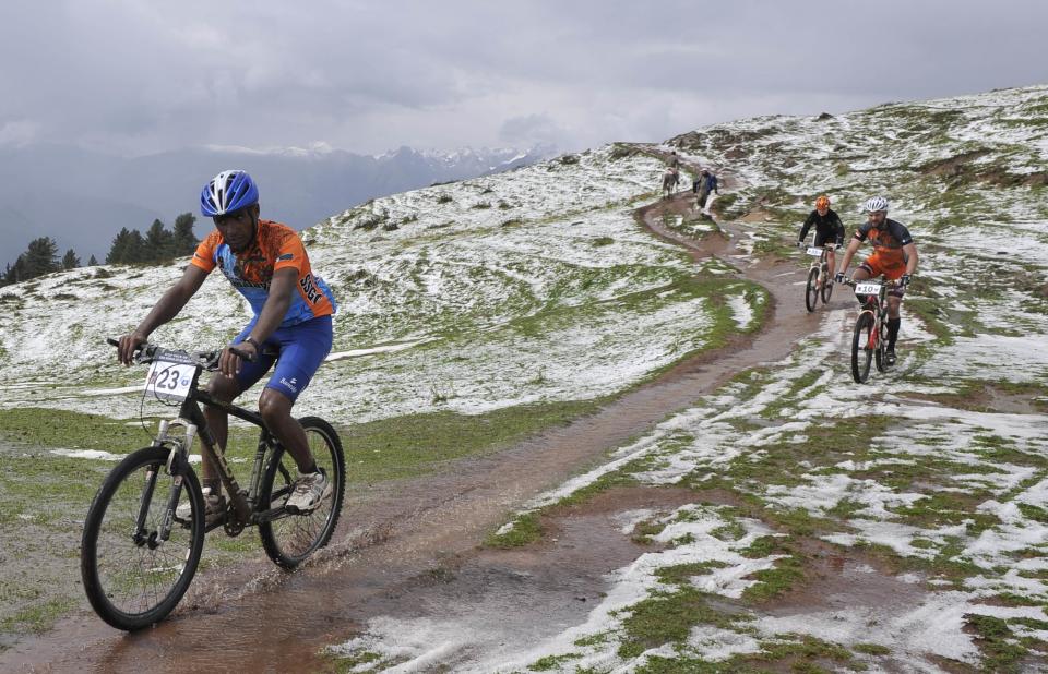 Pakistan's cyclist Asif (L), Irjan Luttenberg of the Netherlands (R) and Ranhilde Luttenberg (C) compete during the third and last stage of the Himalayas 2011 International Mountainbike Race in the mountainous area of Shogran, Pakistan's tourist region of Naran in Khyber Pakhtunkhwa province on September 18, 2011. Slovakia's Martin Haring won the Himalayas 2011 race. AFP PHOTO / AAMIR QURESHI (Photo credit should read AAMIR QURESHI/AFP/Getty Images)