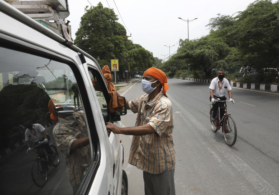 In this June 4, 2020, photo, Indian driver Gangaram, 48, who lost his job and business because of the coronavirus lockdown cleans his vehicle in New Delhi, India. Gangaram used to pick and drop schoolchildren from a New Delhi neighborhood. The job assured him of slim financial security. to relaunch the economy. That's the harsh truth facing workers laid off around the world, from software companies in Israel to restaurants in Thailand and car factories in France, whose livelihoods fell victim to a virus-driven recession that's accelerating decline in struggling industries and upheaval across the global workforce. (AP Photo/Manish Swarup)