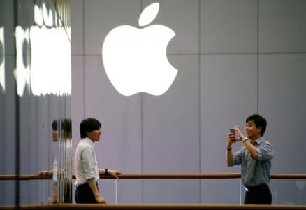 A man uses his phone to take pictures outside an Apple store in Beijing, China July 28, 2016.  REUTERS/Thomas Peter