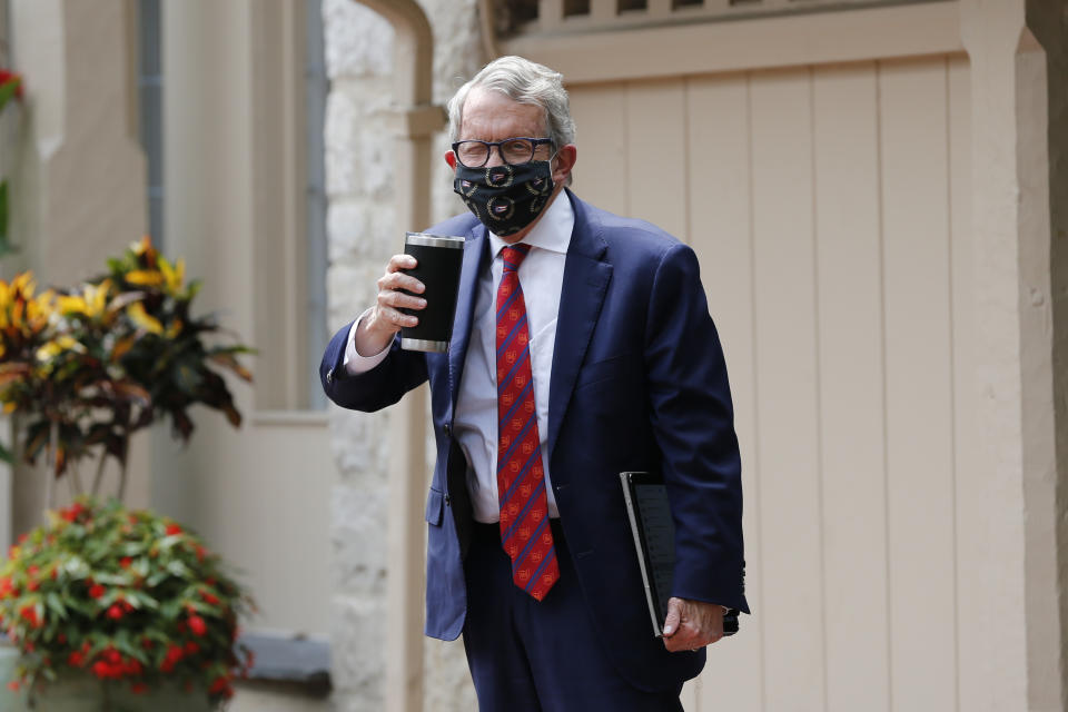 Ohio Gov. Mike DeWine acknowledges members of the media while entering his residence after testing positive for COVID-19 earlier in the day Thursday, Aug. 6, 2020, in Bexley, Ohio. DeWine tested positive using a rapid test Thursday, before testing negative later in the day using a more sensitive laboratory-developed test. No test for coronavirus infection is perfect, and test results can be affected by a variety of factors, including the type of test used, the quality of the sample and when it was taken during the course of any infection. (AP Photo/Jay LaPrete)