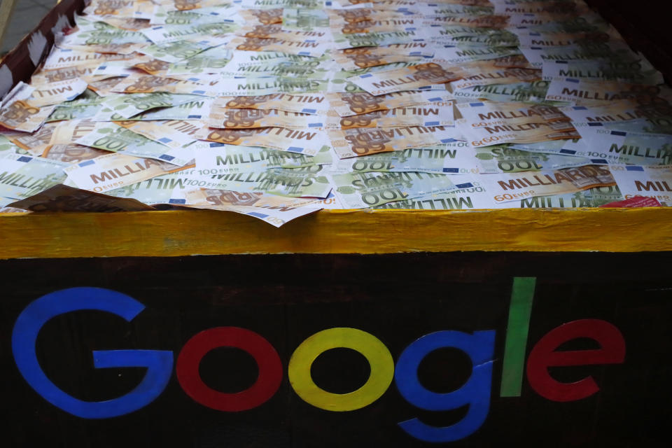 FILE - In this Jan.31, 2019 file photo, a trunk full of fake bank notes is displayed as activists from anti-globalization organisation Attac stage a protest at Google's Paris headquarters to criticize the company's tax evasion policies, in Paris. The French government is unveiling plans to slap a 3 percent tax on the French revenues of internet giants like Google, Amazon and Facebook. (AP Photo/Francois Mori, File)