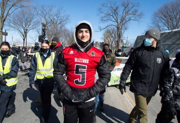 High school football player Isaac Pépin, centre, organized the pro-sports march Sunday.  