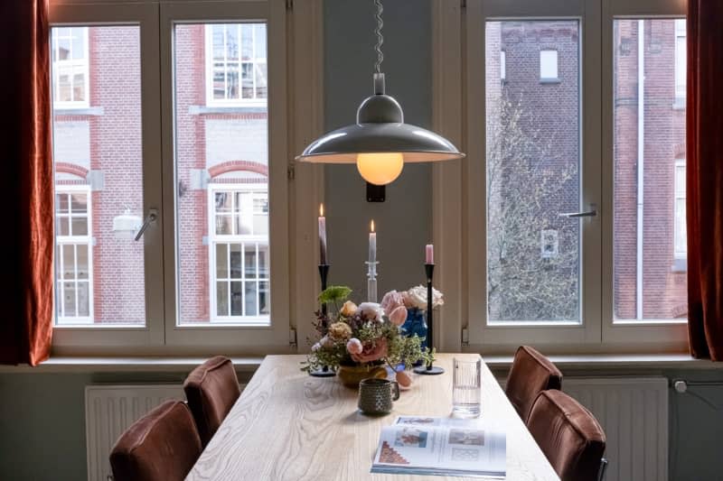 Light wood dining room table with floral arrangement and brown fabric chairs.