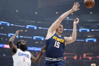 Denver Nuggets center Nikola Jokic, right, passes as Los Angeles Clippers guard James Harden defends during the first half of an NBA basketball game Thursday, April 4, 2024, in Los Angeles. (AP Photo/Mark J. Terrill)