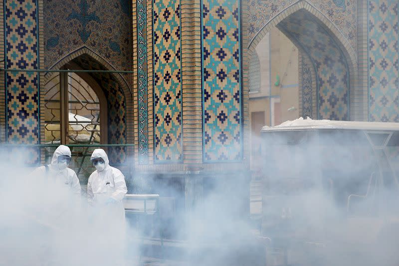 Members of the medical team spray disinfectant to sanitize outdoor place of Imam Reza's holy shrine, following the coronavirus outbreak, in Mashhad