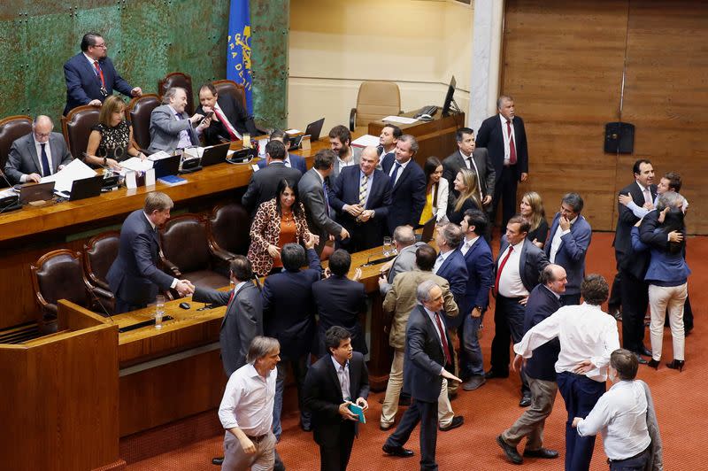 Chilean lawmakers supporting the government celebrate after voting to reject a move to impeach President Sebastian Pinera during a session at the congress in Valparaiso