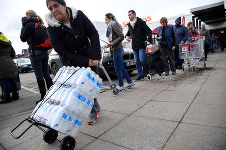 Local residents collect bottled water distributed by Thames Water after mains supplies to homes were cut off following bad weather, in Balham, south London, March 5, 2018. REUTERS/Toby Melville