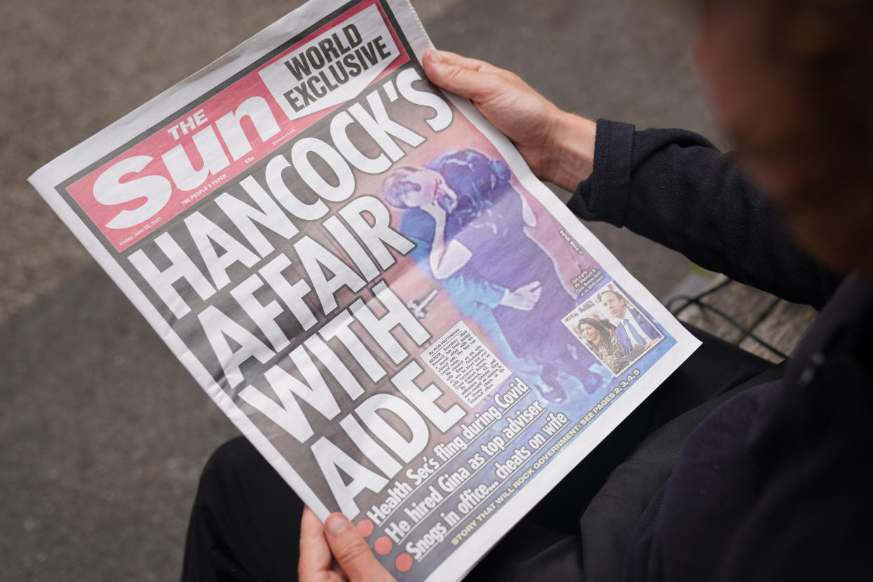 A person reads a copy of the Sun newspaper in Westminster, London, with the story and pictures of Health Secretary Matt Hancock appearing to kiss his adviser Gina Coladangelo, who the newspaper said was hired by Mr Hancock last year. Picture date: Friday June 25, 2021. (Photo by Kirsty O'Connor/PA Images via Getty Images)