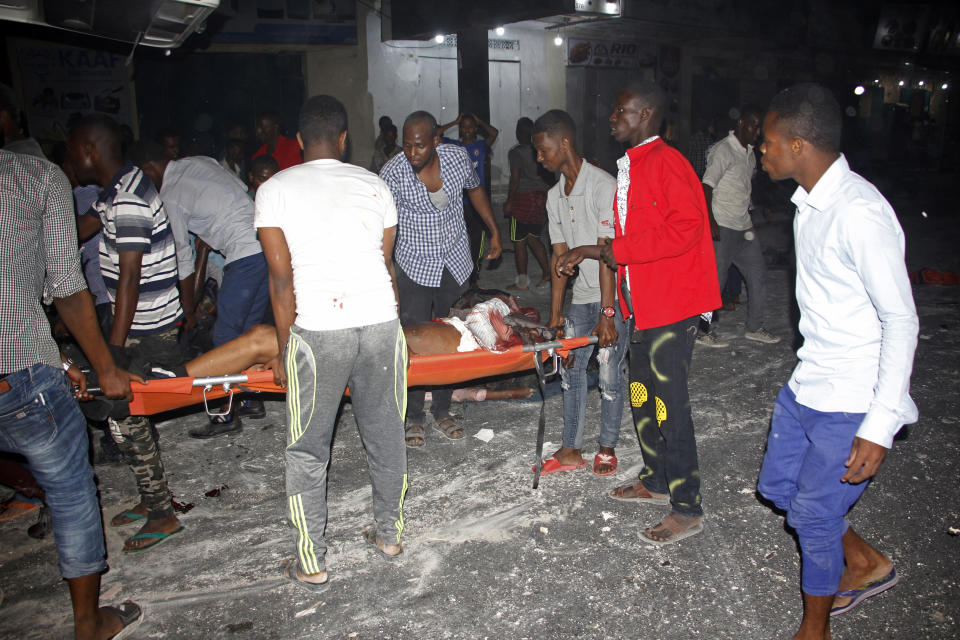 Somalis help an injured person after a car bomb, in Mogadishu, Somalia, Thursday Feb. 28, 2019. At least four people were killed in a powerful explosion late Thursday in the Somali capital, Mogadishu, police said, in an attack that Islamic extremists said was an attempt to bomb a hotel. Militants detonated a car bomb near the residence of Judge Abshir Omar, and security forces stationed outside the house fought off gunmen who tried to force their way into Omar’s house, police officer Mohamed Hussein told The Associated Press. (AP Photo/Farah Abdi Warsameh)