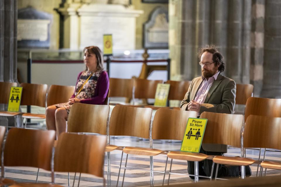 People sit in prayer in the nave of Worcester Cathedral in Worcester, Worcestershire, as it opens for the first time since the UK entered lockdown to reduce the spread of coronavirus.