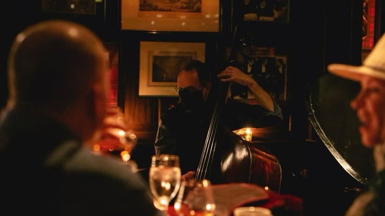 musician playing in dark room with diners