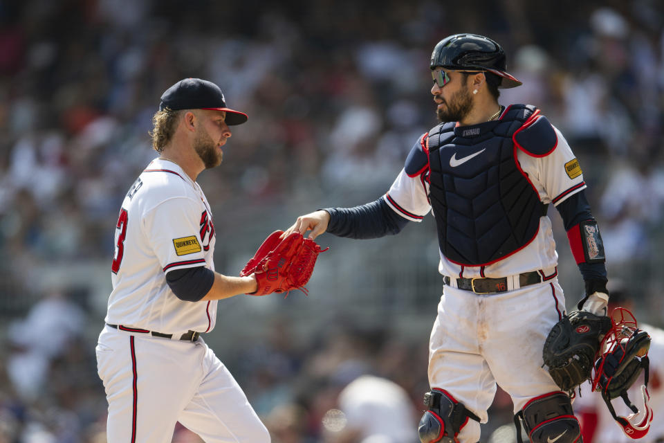 Atlanta Braves catcher Travis d'Arnaud hands the ball to relief pitcher A.J. Minter in the eighth inning of a baseball game against the Pittsburgh Pirates, Sunday, Sept. 10, 2023, in Atlanta. (AP Photo/Hakim Wright Sr.)
