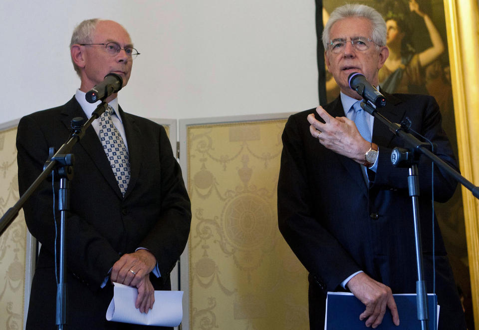 European Council President Herman Van Rompuy, left, and Italian Premier Mario Monti talk to reporters during a meeting on World Economy in Cernobbio, Italy, Saturday, Sept. 8, 2012. Italian Finance Minister Vittorio Grilli says on the sidelines of the annual Ambrosetti Forum on Lake Como on Saturday Italy has no plans to apply for the European Central Bank's bond purchase program. The ECB has pledged to buy unlimited amounts of bonds to help bring down borrowing costs in countries struggling to keep up with high debts. But that plan comes with the caveat that nations who want to apply for the program must first ask for existing bailout funds and submit their economic policies to international scrutiny. (AP Photo/Roberto Monaldo, Lapresse)