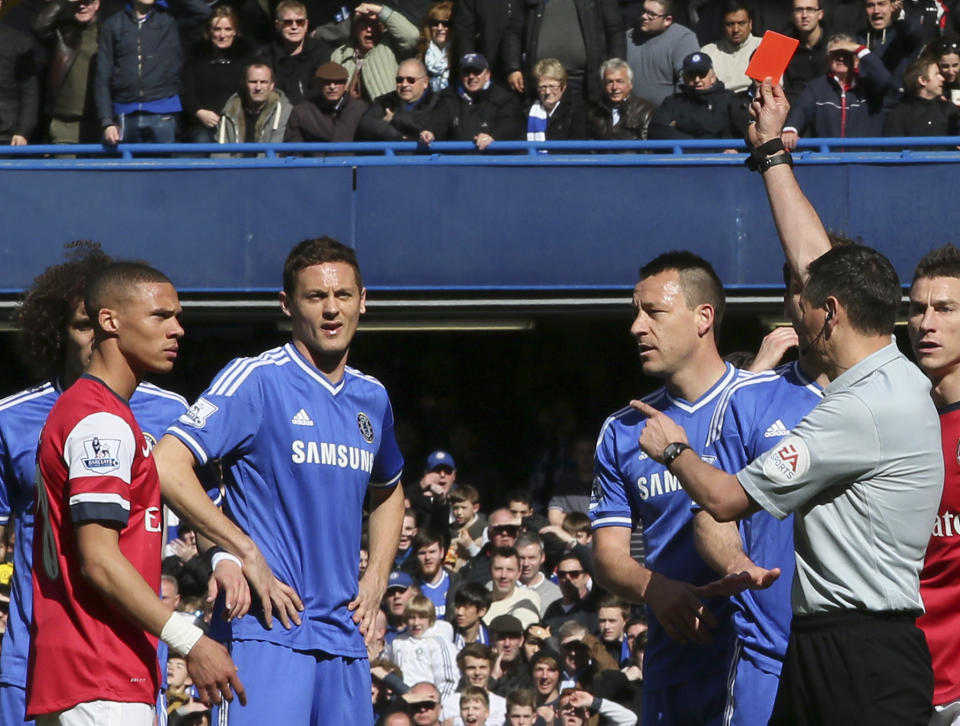 Referee Andre Marriner, in grey, sends off Arsenal's Kieran Gibbs, left, during their English Premier League soccer match between Chelsea and Arsenal at Stamford Bridge stadium in London Saturday, Mar 22 2014. (AP Photo/Alastair Grant)