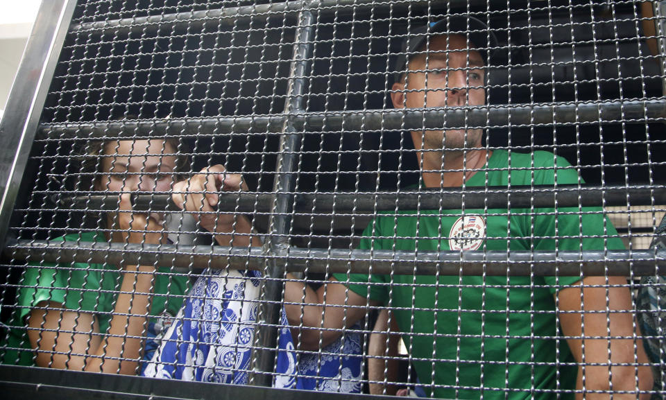 Belarusian model Anastasia Vashukevich, left, and Russian self-styled sex guru Alexander Kirillov, right, look out of a van leaving the Immigration Detention Center for an airport for deportation, in Bangkok, Thailand, Thursday, Jan. 17, 2019. Thai officials say they are deporting Vashukevich who claimed last year that she had evidence of Russian involvement in helping elect Donald Trump president. Kirillov was arrested for holding a sex training seminar in Pattaya, Thailand, in February 2018. (AP Photo/Sakchai Lalit)