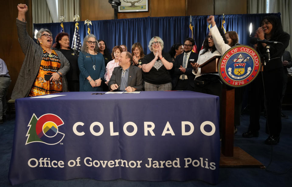 Supporters cheer after Colorado Gov. Jared Polis signed the second of three bills that enshrine protections for abortion and gender-affirming care procedures and medications during a ceremony with bill sponsors and supporters Friday, April 14, 2023, in the State Capitol in Denver. (AP Photo/David Zalubowski)