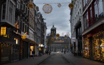 FILE - In this Jan. 14, 2021, file photo, closed stores on Dam street and the Royal Palace on Dam Square, rear, are seen in Amsterdam. The Dutch government this week extended by three weeks the tough lockdown in force since mid-December amid fears that coronavirus infection rates are not declining quickly enough and fears about a new, more transmissible variant of the virus. (AP Photo/Peter Dejong, File)