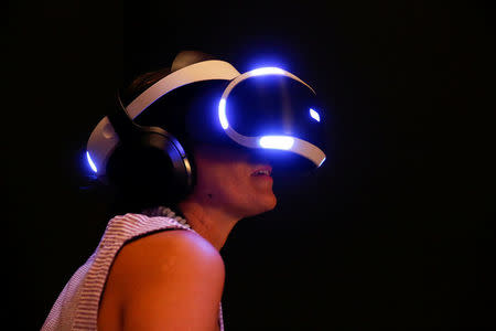 A woman tries on earphones and a headset used for virtual reality at the Venice Virtual Reality a competition during 74th Venice Film Festival in Venice, Italy, August 29, 2017. REUTERS/Alessandro Bianchi