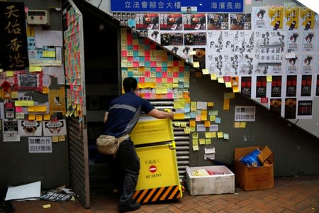 A worker put his stuff into a room under a pedestrian bridge in Hong Kong